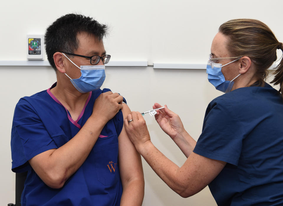 Victoria's Deputy Chief Health Officer Allan Cheng and Nurse Karen Lasky (right) administering the vaccine against Covid-19 at Alfred Hospital, Melbourne, Friday, March 5, 2021