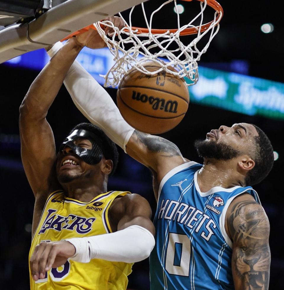 Lakers forward Rui Hachimura, left, dunks over Hornets forward Miles Bridges during a game last week at Crypto.Com Arena.