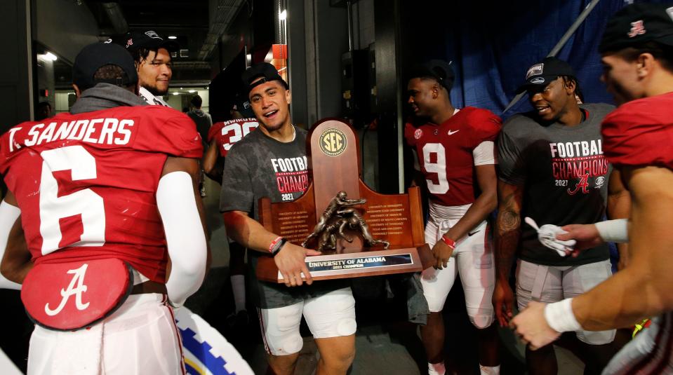 Dec 4, 2021; Atlanta, GA, USA; Alabama linebacker Henry To'o To'o (10) holds the championship trophy as the team makes their way to the locker room after the SEC championship game at Mercedes-Benz Stadium. Alabama defeated Georgia 41-24. Mandatory Credit: Gary Cosby Jr.-USA TODAY Sports