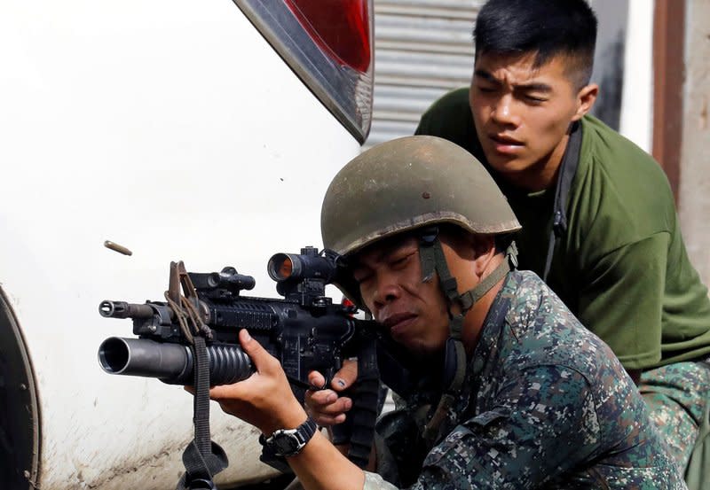 A Philippine Marine fires his weapon towards the stronghold of Maute group in Marawi City, southern Philippines. REUTERS/Erik De Castro