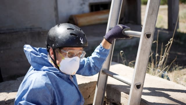 Michael Ketterer lowers himself into an empty water storage tank to collect dust samples from the bottom of it.