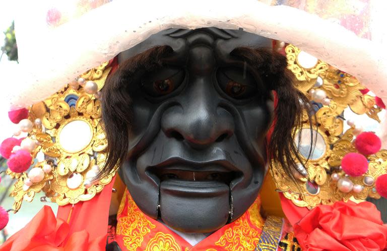 A man dressed in a Taoist god costume attends the annual "Holy Pigs" Festival outside the Zushi Temple in Shanhsia district in the New Taipei City, on February 24, 2015