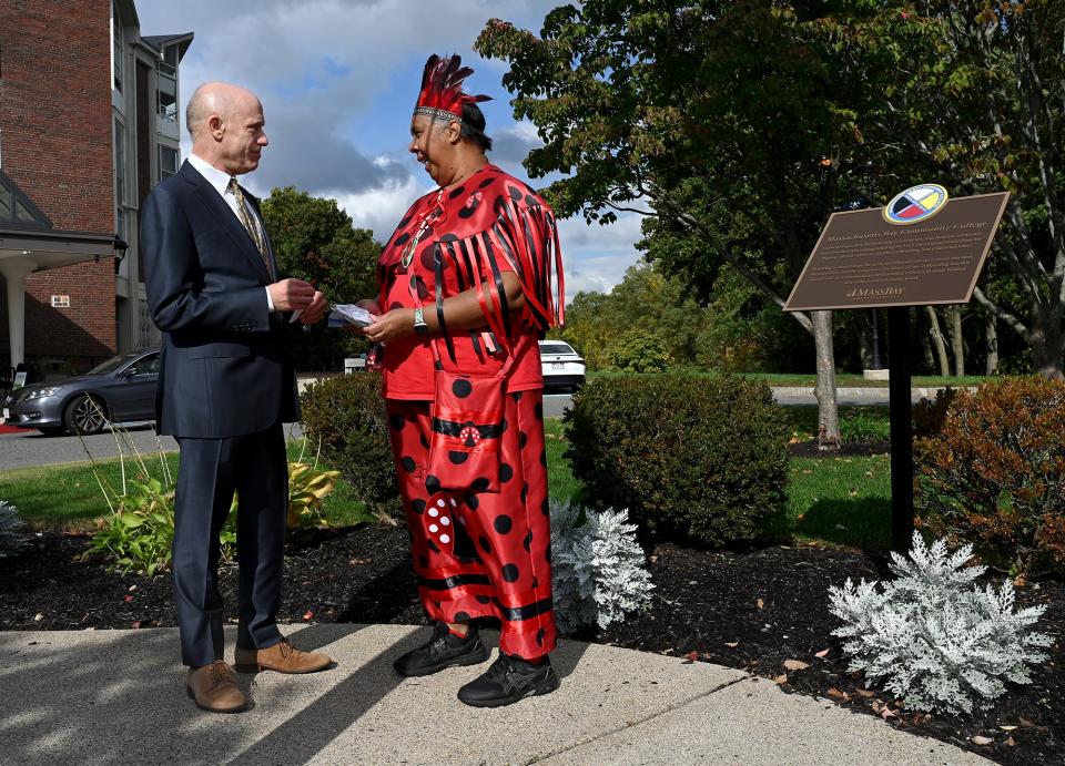 Denise Pruitt, left, a health science professor at MassBay Community College who's also known as Chief Ladybug of the Croatan tribe, chats with college President David Podell near a new land acknowledgement plaque in honor of indigenous people, Oct. 18, 2022.