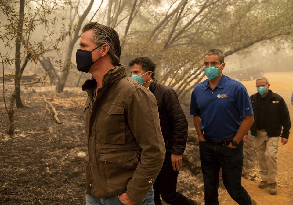 Gov. Gavin Newsom, left, tours North Complex Fire zone with California Secretary for Environmental Protection Jared Blumenfeld, second left, and California Secretary for Natural Resources Wade Crowfoot in Butte County on Friday, Sept. 11, 2020, outside of Oroville, Calif. Newsom toured the fire-ravaged region Friday and strongly asserted that climate change was evident and pledged to redouble efforts to “decarbonize” the economy. (Paul Kitagaki Jr./The Sacramento Bee via AP, Pool)
