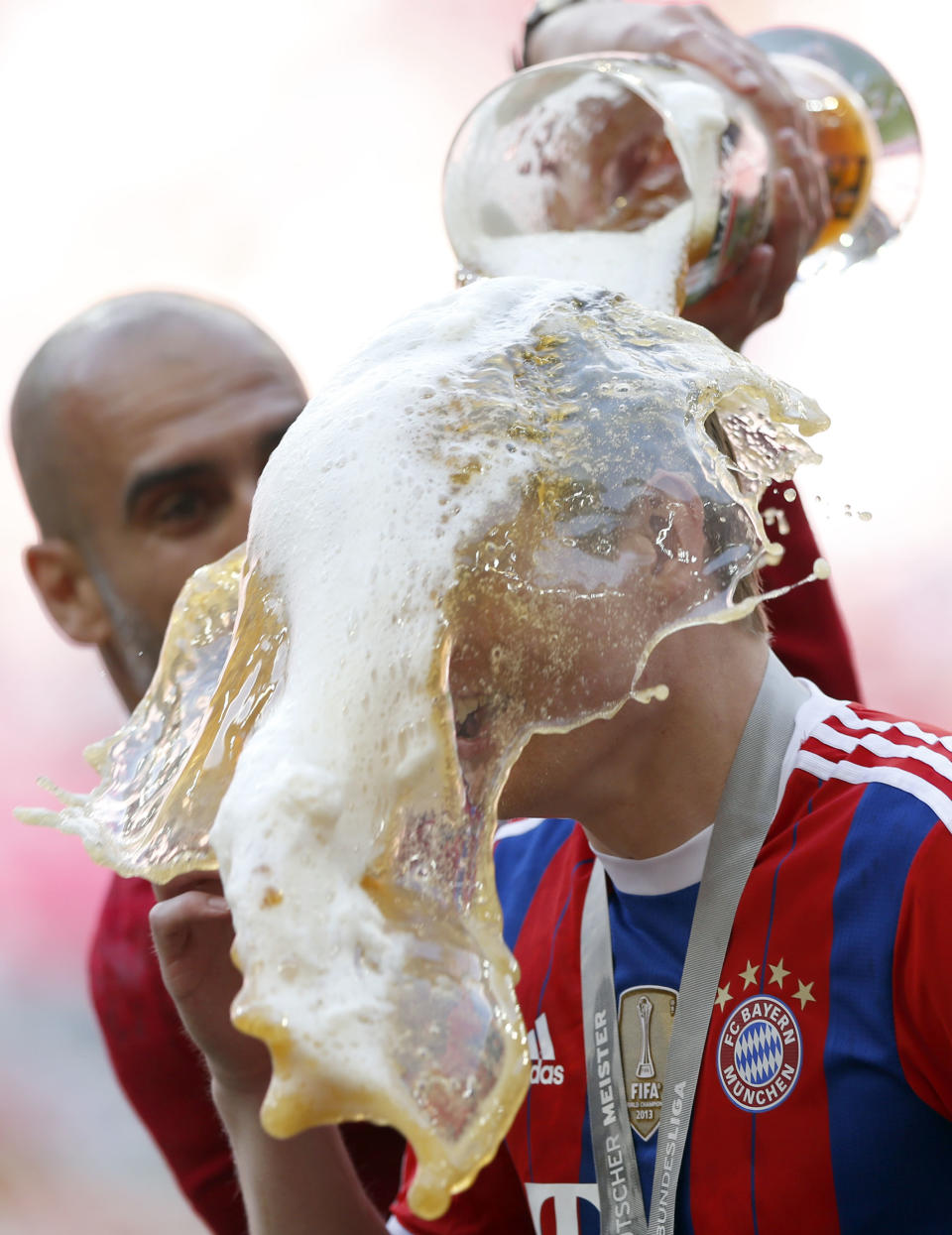 Bayern head coach Pep Guardiola of Spain showers player Toni Kroos with beer after winning the German Soccer Championships after the season's last match between FC Bayern Munich and VfB Stuttgart, in Munich, southern Germany, Saturday, May 10, 2014. (AP Photo/Matthias Schrader)