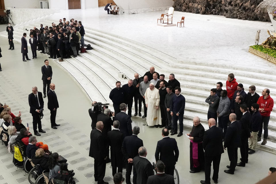 Pope Francis poses with people attending his weekly audience in the weekly general audience in the Paul VI Hall at the Vatican, Wednesday, Dec. 28, 2022. (AP Photo/Alessandra Tarantino)