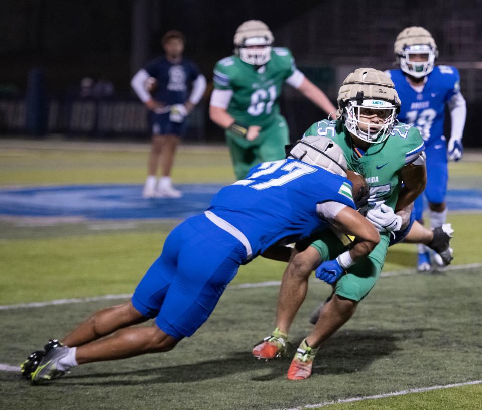 Kasmir Absolu (27) stops Daryel Garcia (25) during the spring football game at the University of West Florida in Pensacola on Thursday, March 9, 2023.