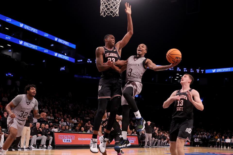 Nov 16, 2023; Brooklyn, New York, USA; St. Bonaventure Bonnies guard Mika Adams-Woods (3) drives to the basket against Oklahoma State Cowboys center Brandon Garrison (23) and guard Connor Dow (13) during the first half at Barclays Center. Mandatory Credit: Brad Penner-USA TODAY Sports