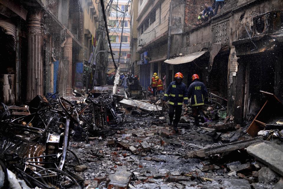 Bomberos trabajan entre edificios que ardieron en un incendio nocturno en Daca, Bangladesh, el 21 de febrero de 2019. La primera ministra de Bangladesh Sheikh Hasina visitó el sábado a algunas de las personas heridas en el incendio. (AP Foto/Mahmud Hossain Opu )