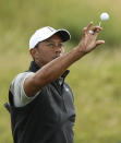 Tiger Woods of the United States catches a golf ball as he prepares to hit practice shots ahead of the start of the British Open golf championships at Royal Portrush in Northern Ireland, Tuesday, July 16, 2019. The British Open starts Thursday. (AP Photo/Jon Super)