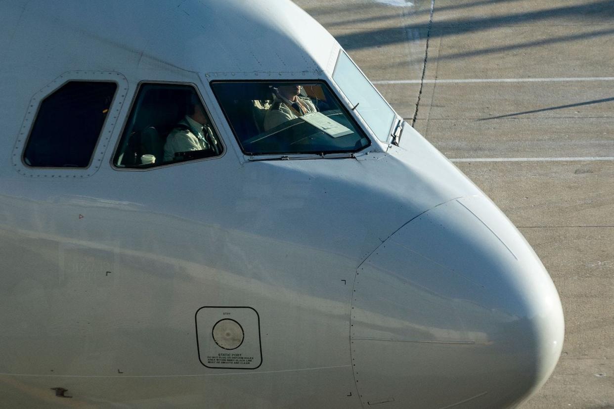 Pilots sit in the cockpit of an American Airlines jet that's waiting on the tarmac.