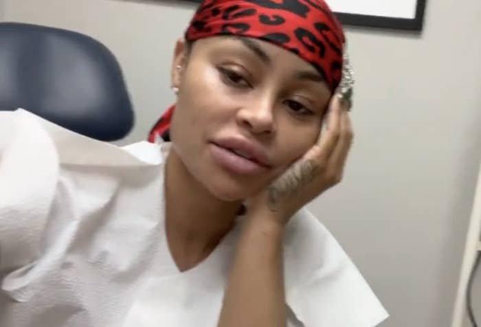 Closeup of Blac Chyna in the doctor's office with her head in her hand as she talks