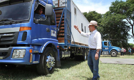 Colombia's President Juan Manuel Santos greets a driver carrying the last container with surrendered weapons delivered by FARC rebels to a UN observer in La Guajira, Colombia August 15, 2017. Colombian Presidency/Handout via REUTERS