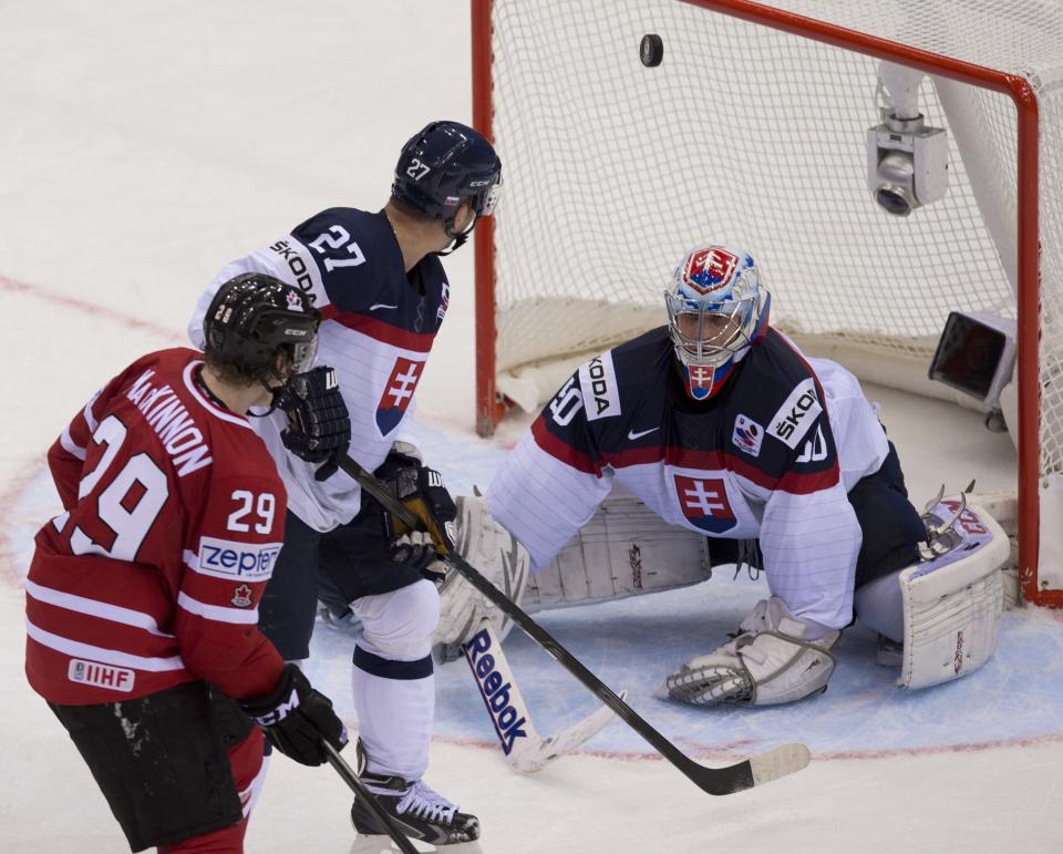 Canada's Nathan MacKinnon watches the puck enter the net behind Slovakia goalie Jan Laco as teammate Ladislav Nagy looks on during third period action at the IIHF Ice Hockey World Championship in Minsk, Belarus, on Saturday, May 10, 2014. (AP Photo/The Canadian Press, Jacques Boissinot)