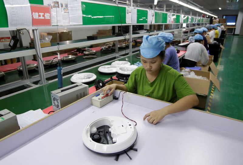FILE PHOTO: An employee works on the production line of a robot vacuum cleaner at a factory of Matsutek in Shenzhen