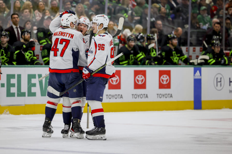 Washington Capitals left wing Beck Malenstyn (47) and right wing Nicolas Aube-Kubel (96) celebrate with defenseman Rasmus Sandin (38) after Sandin's goal during the second period of an NHL hockey game against the Dallas Stars, Saturday, Jan. 27, 2024, in Dallas. (AP Photo/Gareth Patterson)