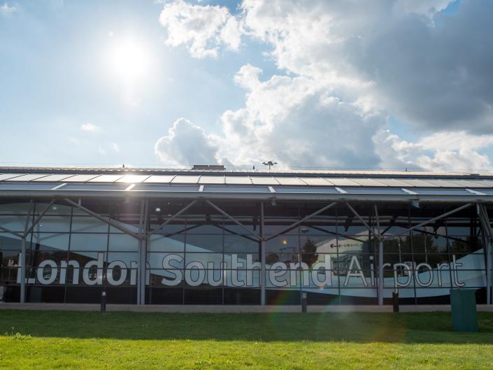 A photograph of London Southend Airport is printed on the windows outside.  The sky is visible at the top of the picture.