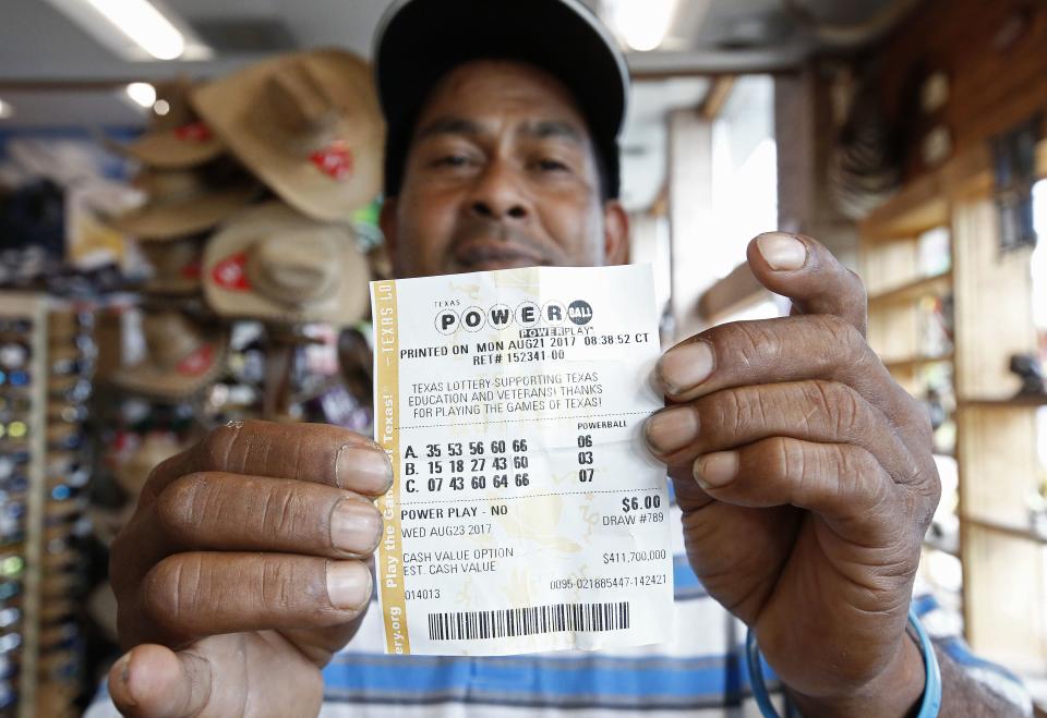 <p>A man holds up a Powerball lottery ticket he purchased at a gas station in Dallas, Texas, Aug. 23, 2017. The Powerball is at 700 million US dollars (593 million euro). (Photo: Larry W. Smith/EPA-EFE/REX/Shutterstock) </p>