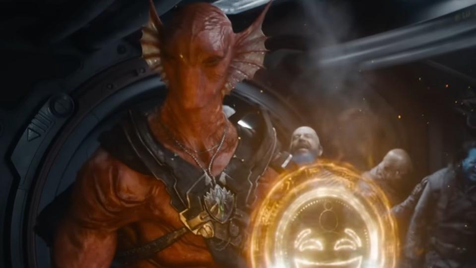 The red dragon like humanoid creature Kurgarr with his floating yellow smiley face in front of him in Guardians of the Galaxy Vol. 3