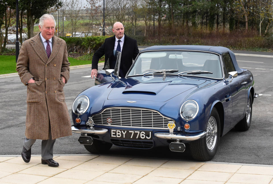 The Prince of Wales with his Aston Martin DB6 as he arrives for a visit to the Aston Martin Lagonda factory at St Athan in Barry, Wales.