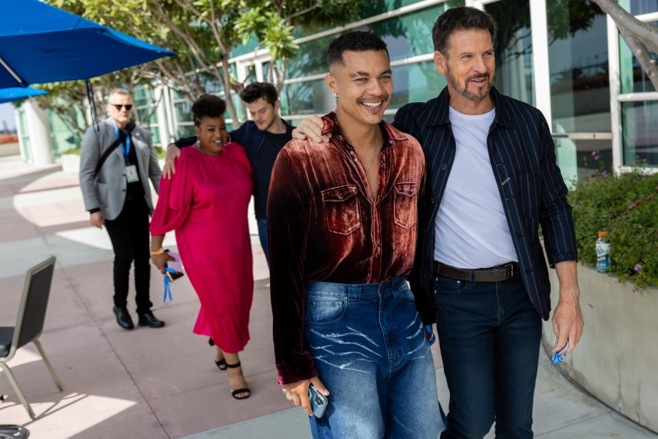 Two actors walk down a street