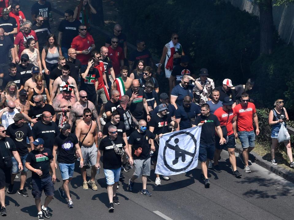 Hungarian fans march with an anti-kneeling banner towards the Puskas Arena in Budapest. (AP)