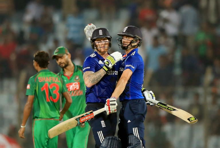 England's cricket players Chris Woakes (R) and Ben Stokes (L) celebrate after winning the final One Day International cricket match against Bangladesh in Chittagong on October 12 , 2016