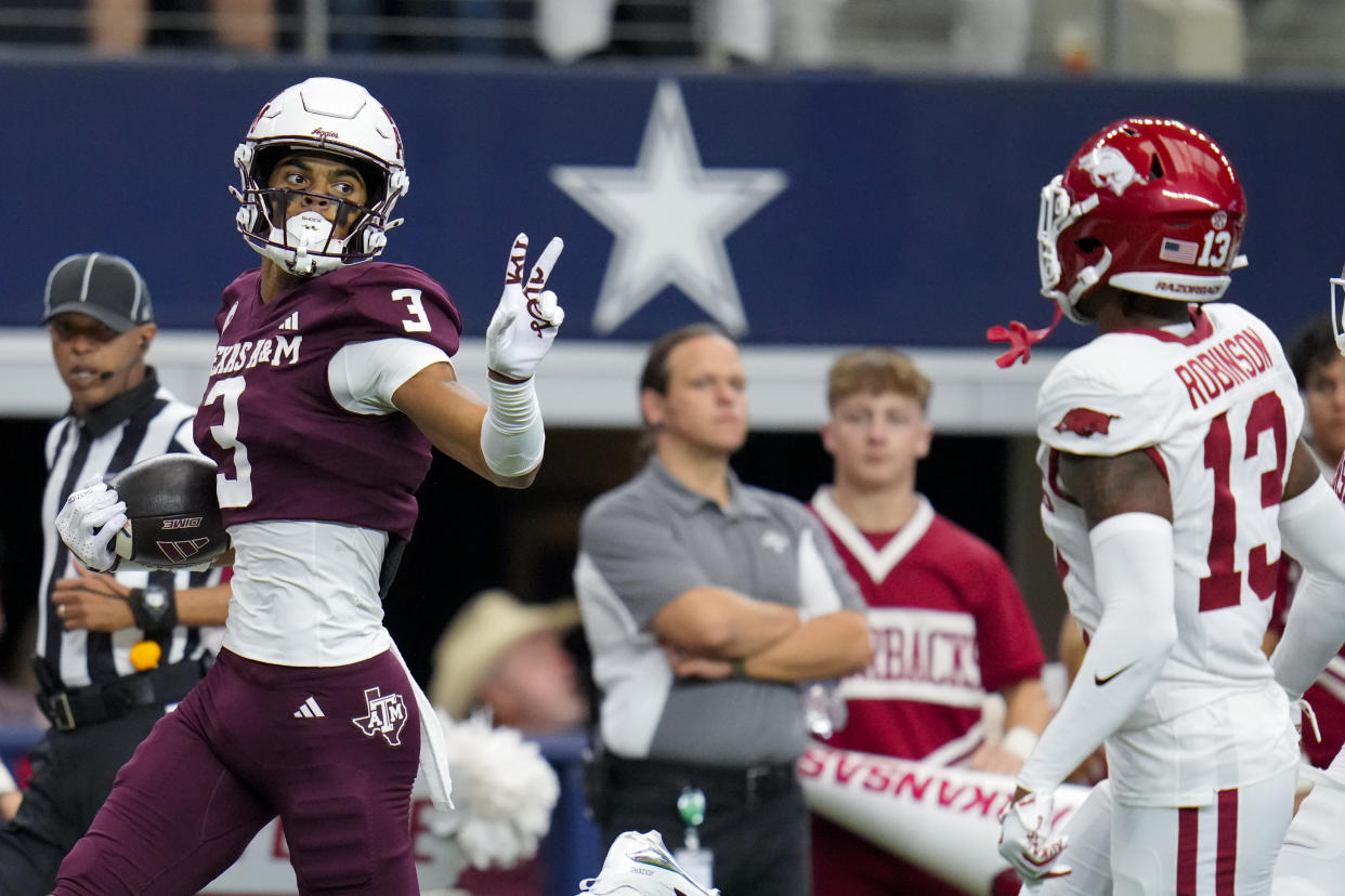 Texas A&M wide receiver Noah Thomas (3) gestures at Arkansas defensive back Marquise Robinson (13) while scoring on a long touchdown reception during the first half of an NCAA college football game, Saturday, Sept. 28, 2024, in Arlington, Texas. (AP Photo/Julio Cortez)