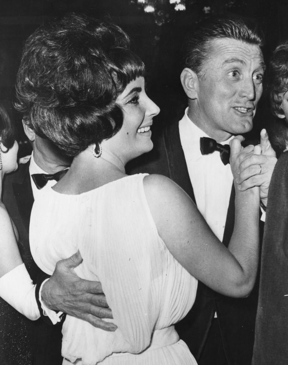 <p>Douglas dances with actress Elizabeth Taylor at a party for <em>Spartacus</em> in Rome. </p>