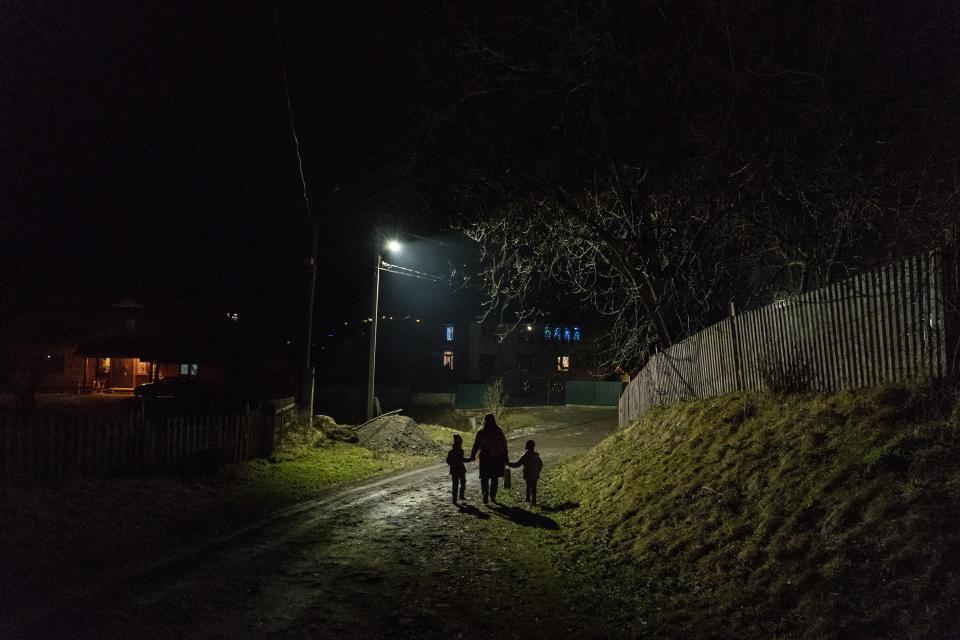 After a long working day Dr. Viktoria Mahnych and her two daughters walk to her parents to celebrate an eve of the Orthodox Christmas in Iltsi village, Ivano-Frankivsk region of Western Ukraine, Wednesday, Jan. 6, 2021. Ukraine is struggling to contain the coronavirus pandemic that has inundated its overburdened medical system, as Dr. Viktoria Mahnych goes door to door providing much needed help to patients.(AP Photo/Evgeniy Maloletka)