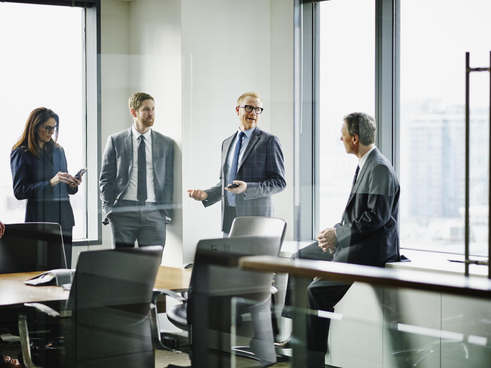 Business executives in discussion in office conference room after team meeting