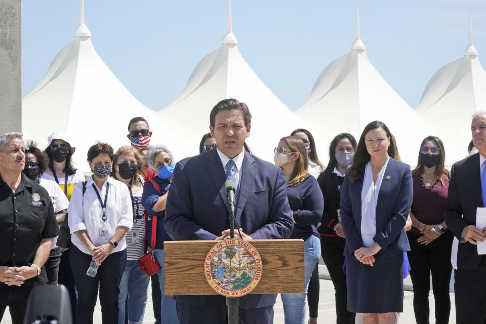 Florida Gov. Ron DeSantis, center, speaks during a news conference surrounded by officials and cruise workers on April 8, 2021, at PortMiami in Miami, Fl. (Wilfredo Lee/AP)