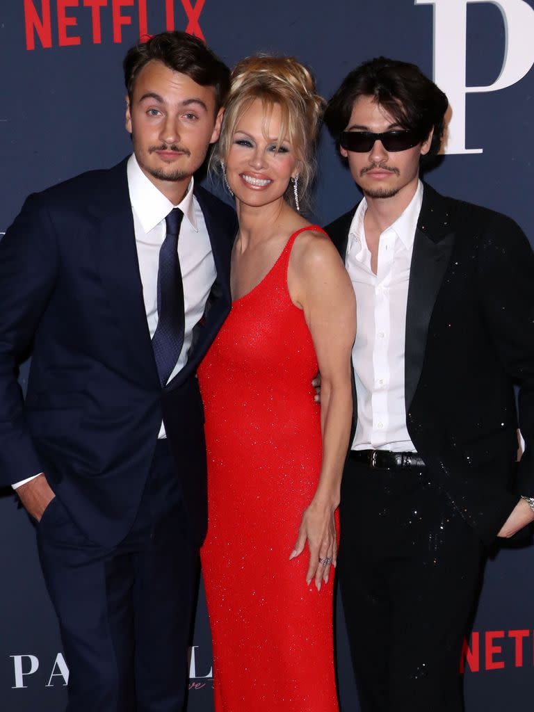 Pamela Anderson posa con sus hijos, Brandon y Dylan -fruto del matrimonio de la actriz con el músico Tommy Lee- durante la premiere en Los Ángeles de Pamela, una historia de amor, la serie que estrenó Netflix. La ex Baywatch se llevó todas las miradas gracias a su espectacular vestido rojo

