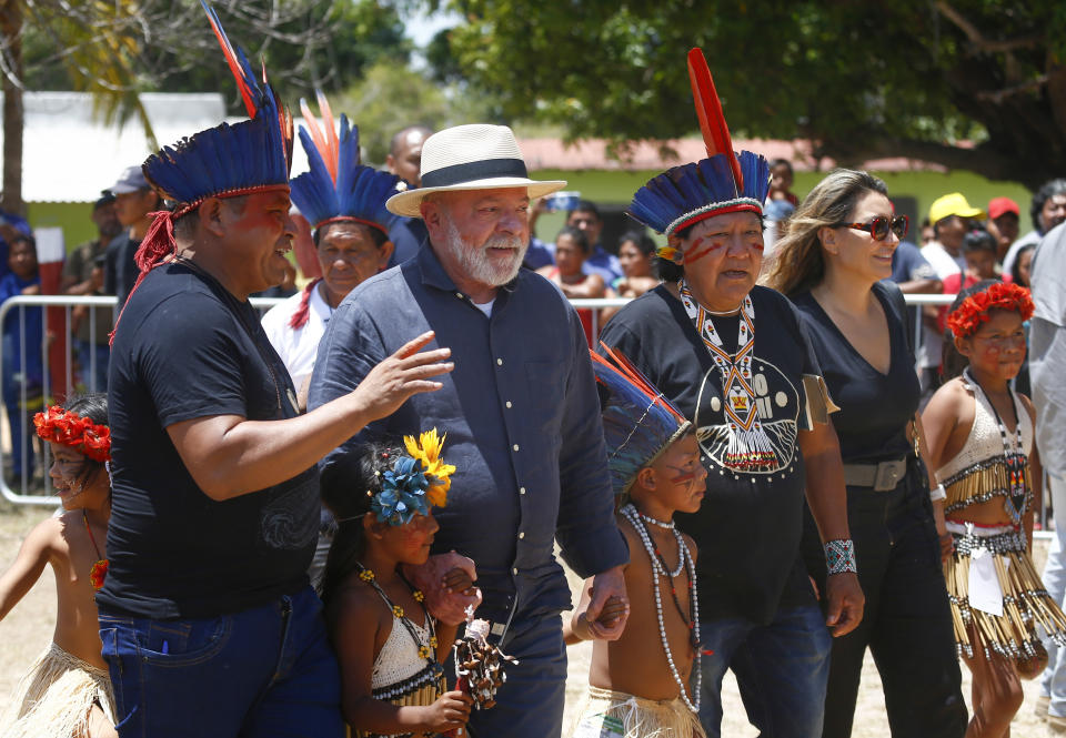 Brazil's President Luiz Inacio Lula da Silva, second left, and his wife Rosangela Silva, second from right, arrive to meet with Indigenous leaders at Caracarana Lake Regional Center in Normandia, on the Raposa Serra do Sol Indigenous reserve in Roraima state, Brazil, Monday, March 13, 2023. Hundreds of indigenous leaders from several ethnicities are meeting to discuss their rights, environment, sustainability, land demarcation and illegal mining. (AP Photo/Edmar Barros)