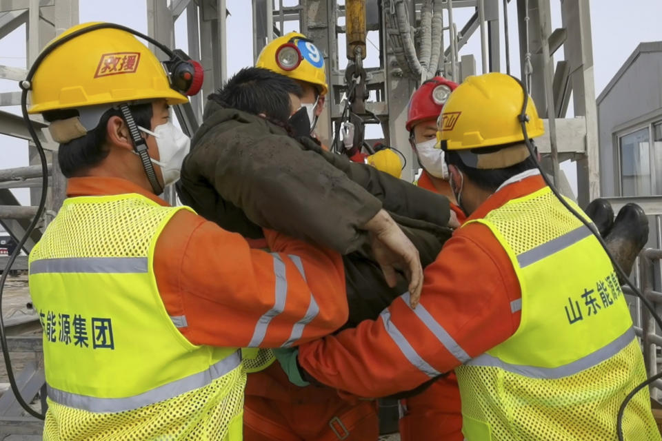 In this photo released by Xinhua News Agency, rescuers carry a miner who was trapped in a gold mine in Qixia City in east China's Shandong Province, Sunday, Jan. 24, 2021. Rescuers in China on Sunday lifted several trapped miners to the surface who were trapped for two weeks after an explosion in a northern gold mine, state media reported. (Luan Qincheng/Xinhua via AP)