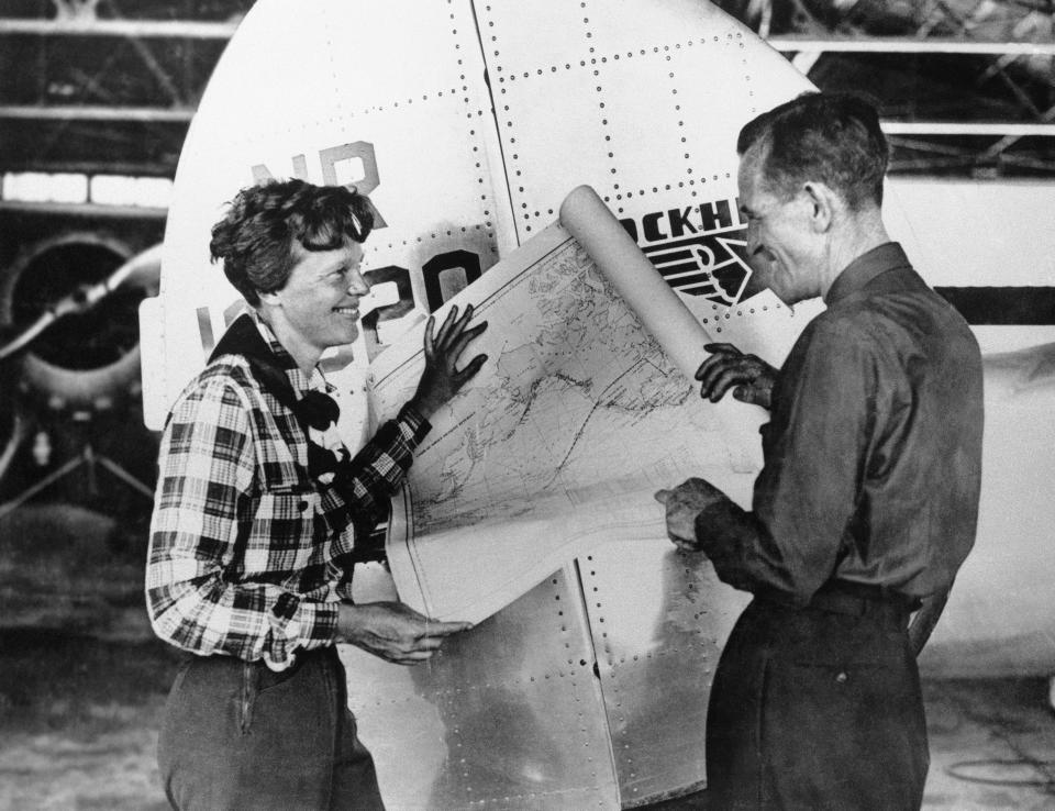 FILE - In this undated photo, Amelia Earhart, left, and navigator Fred Noonan pose with a map of the Pacific showing route of their last flight in this undated photo. A $2.2 million expedition that hoped to find wreckage from famed aviator Amelia Earhart's final flight is on its way back to Hawaii without the dramatic, conclusive plane images searchers were hoping to attain. But the group leading the search, The International Group for Historic Aircraft Recovery, still believes Earhart and her navigator crashed onto a reef off a remote island in the Pacific Ocean 75 years ago this month, its president told The Associated Press on Monday, July 23, 2012. (AP Photo, File)