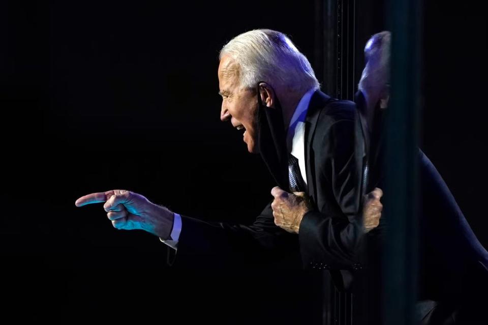 President-elect Joe Biden leans toward the cheering crowd, past the edge of protective glass on stage, in Wilmington, Delaware (AP)