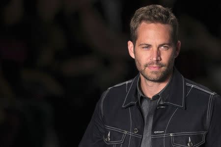 U.S. actor Paul Walker presents a creation from Colcci's 2013/2014 summer collection during Sao Paulo Fashion Week March 21, 2013. REUTERS/Filipe Carvalho