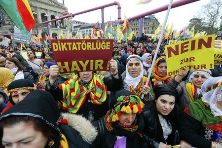 People hold placards with the slogan "No to dictatorship" (R) and "Dictatorlie No" (L) during a demonstration organised by Kurds, in Frankfurt, Germany, March 18, 2017. REUTERS/Ralph Orlowski