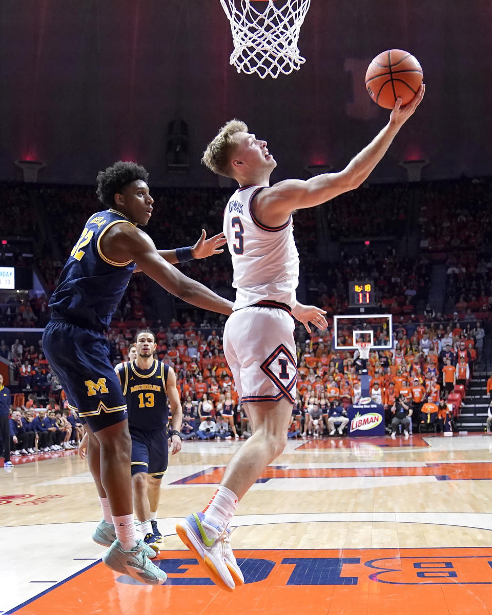 Illinois' Marcus Domask (3) scores past Michigan's Tarris Reed Jr. during the second half of an NCAA college basketball game Tuesday, Feb. 13, 2024, in Champaign, Ill. Illinois won 97-68. (AP Photo/Charles Rex Arbogast)