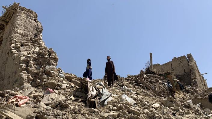 Image shows survivors on top of rubble