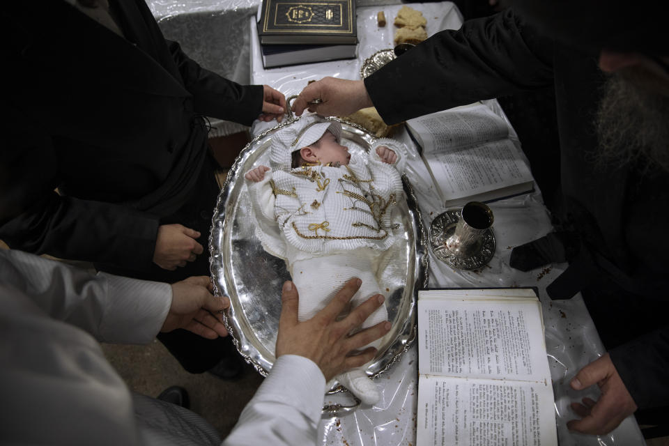 Yaakov Tabersky, lest, presented his firstborn son, Yossef on a silver platter to Jewish priests from the Lelov Hassidic dynasty, during the "Pidyon Haben" ceremony in Beit Shemesh, Israel, Thursday, Sept. 16, 2021. The Pidyon Haben, or redemption of the firstborn son, is a Jewish ceremony hearkening back to the biblical exodus from Egypt. (AP Photo/Oded Balilty)