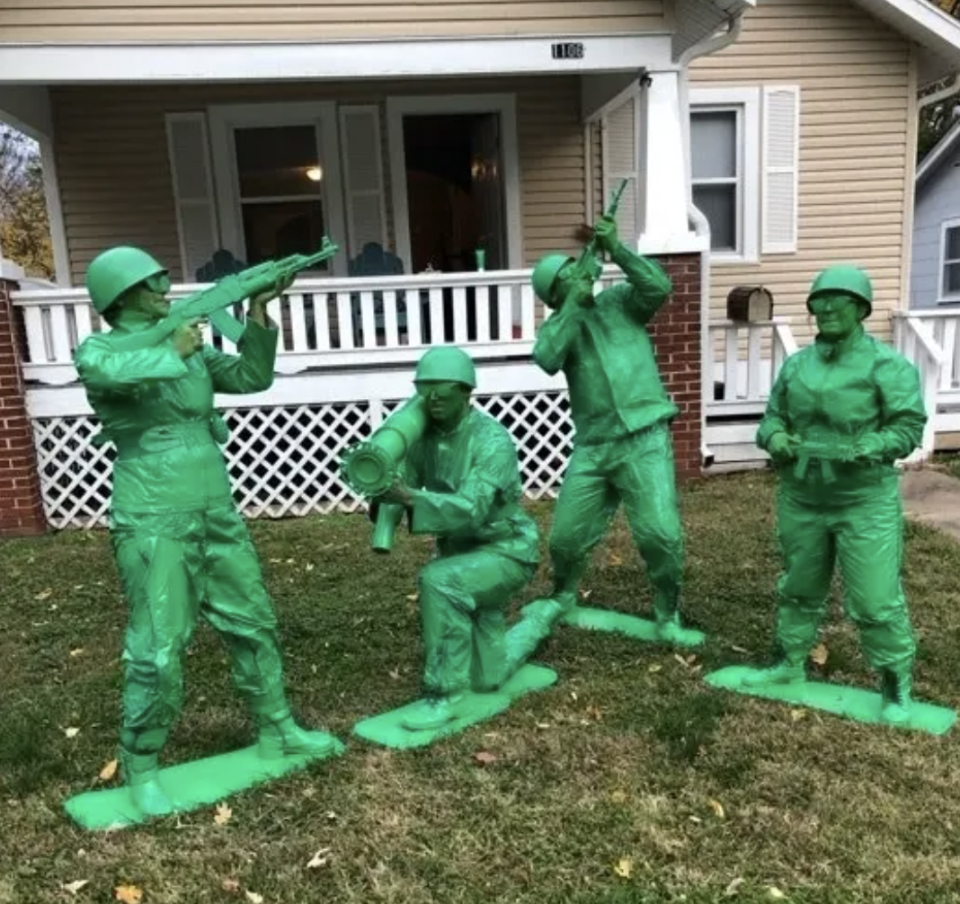 Four people painted green and posing as toy soldier toys