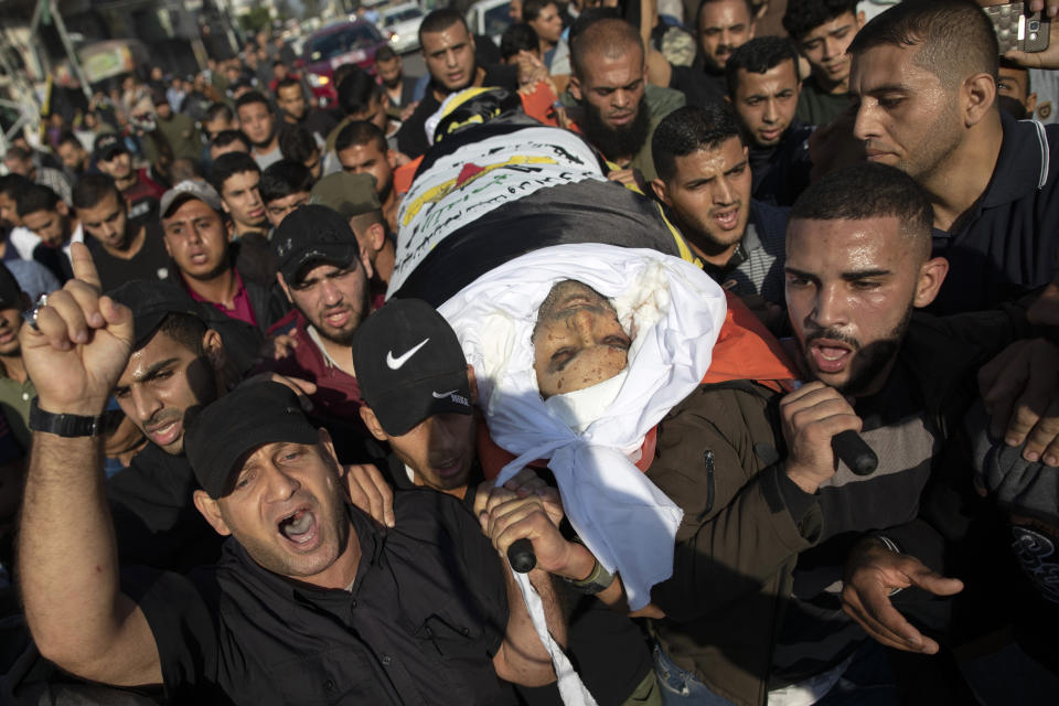 Palestinians chant angry slogans as they carry the body of Islamic Jihad commander, Bahaa Abu el-Atta, who was killed with his wife by an Israeli missile strike hit his house early morning, during his funeral in Gaza City, Tuesday, Nov. 12, 2019. (AP Photo/Khalil Hamra)