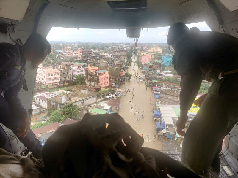 Members of Indian Air Force drop relief goods from a plane in the flood-affected areas in Silchar