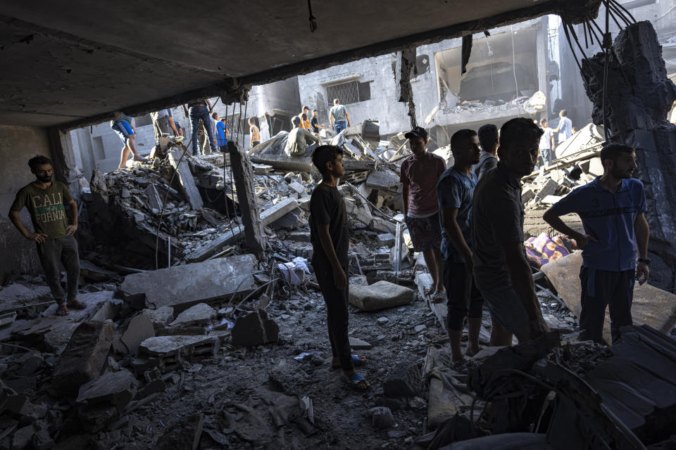 Palestinos buscan cadáveres y sobrevivientes entre los restos de un edificio residencial arrasado tras un ataque aéreo israelí sobre el campo de refugiados de Al Shati, el 12 de octubre de 2023. (AP Foto/Fatima Shbair)