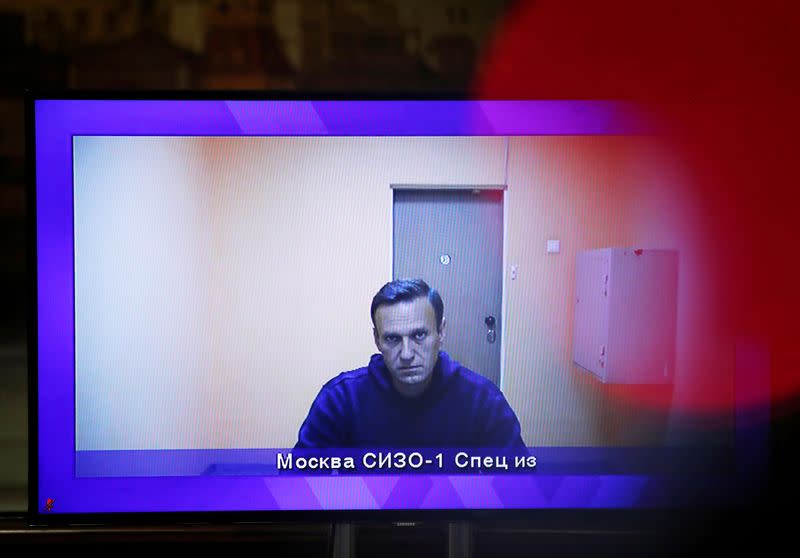 FILE PHOTO: Russian opposition leader Alexei Navalny is seen on a screen via a video link during a court hearing to consider an appeal on his arrest, outside Moscow