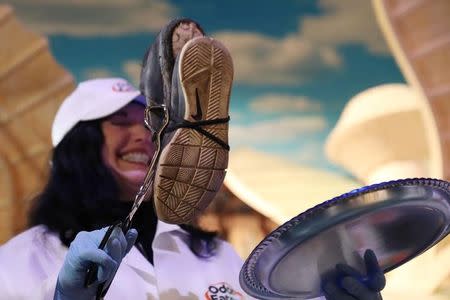 A judge examines a sneaker during the Odor-Eater's Rotten Sneaker Contest at Ripley's Believe It or Not! Times Square in New York, U.S., March 28, 2017. REUTERS/Shannon Stapleton