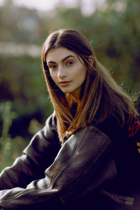 brunette girl in an eighties bomber jacket 