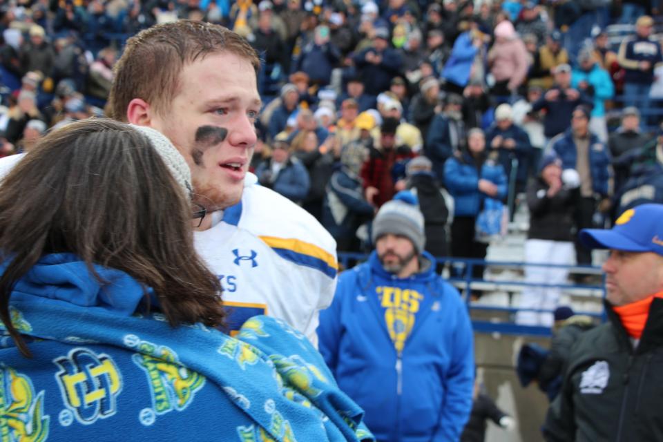 Wes Genant receives a hug after SDSU's loss to Montana State in the FCS semifinals.